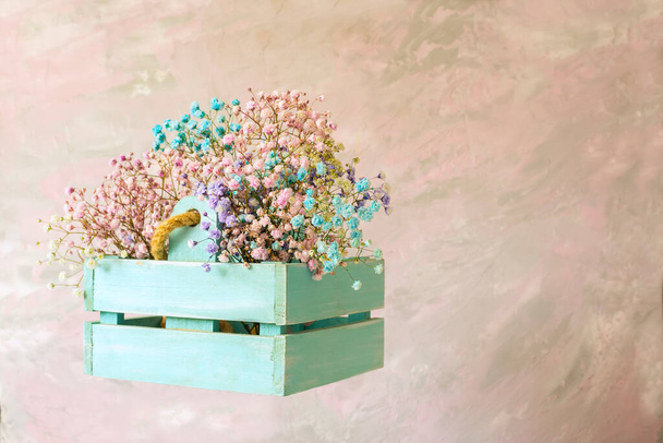 delicate bouquet with pink small flowers in a in a wooden box on a light background  - Valokuva, kuva