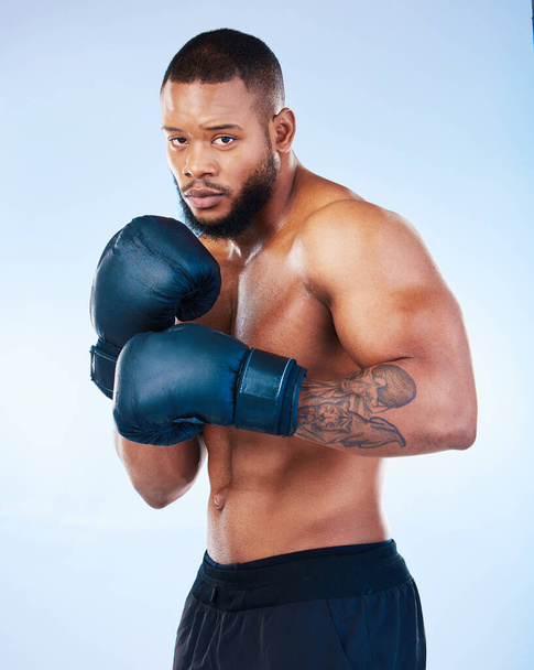 Boxer man, training and studio portrait for wellness, fight and focus for competition by blue background. Young boxing athlete, strong body or gloves for safety, fist and performance in sport workout. - Photo, image