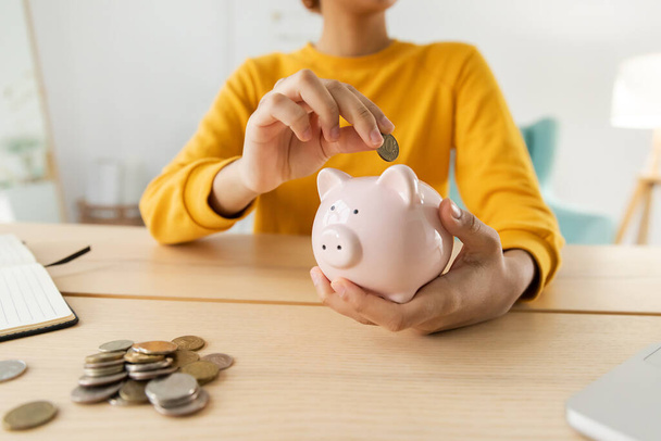 Saving money investment for future. African american girl holding pink piggy bank and putting money coin. Saving investment budget business wealth retirement financial money banking concept - Foto, Imagen