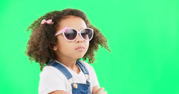 Green screen, fashion and face of child with sunglasses for trendy clothes, style and funky accessories in studio. Cool, happy and portrait of confident girl with dance, comic and serious attitude. - Filmati, video