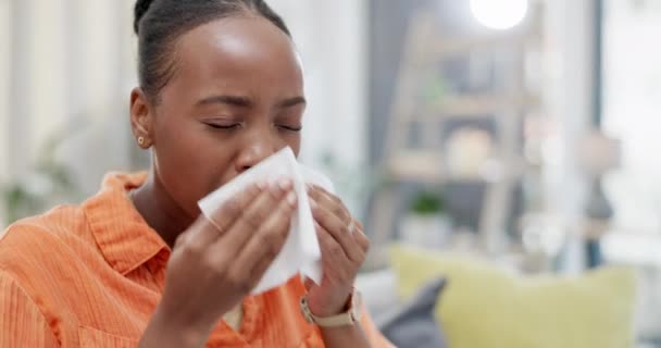 Mujer negra enferma, tejido y nariz en casa para alergias, virus del resfriado y niña enferma. Estornudos, gripe y alergia de la mujer en el sofá por problemas de salud en invierno, riesgo médico covid y sinusitis enfermedad. - Imágenes, Vídeo