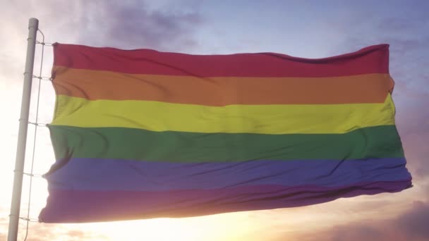 LGBT bayrağı rüzgarda, gökyüzünde ve arka planda dalgalanıyor. İçerme ve ilerleme renkleriyle LGBT Gökkuşağı Bayrağı. - Video, Çekim