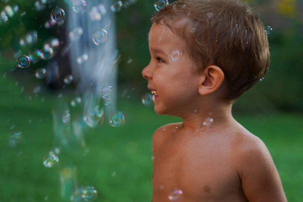 Little baby playing with colorful soap bubbles. A fun holiday with balls and bubbles - Foto, Bild