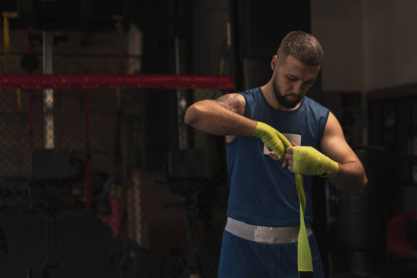 boxeur masculin enveloppe ses bras avant un combat dans Jeune sportif prépare combat close-up Concept sportif - Photo, image