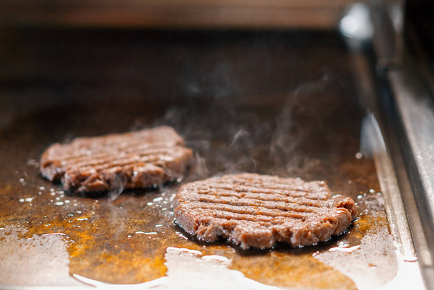 Professional restaurant kitchen close-up of hamburger patties on grill smash burger beefsteak - Foto, immagini