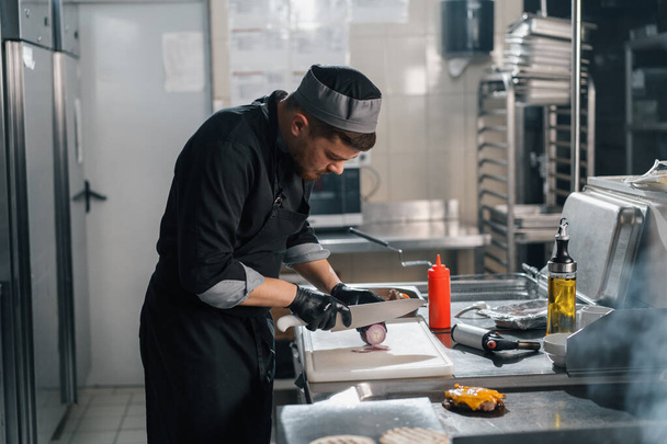 професійна кухня в готельному ресторані шеф-кухаря з кухонним ножем ріже овочі бургер
 - Фото, зображення