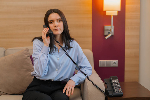 Una hermosa mujer llama en la recepción del hotel Travel Business lady - Foto, imagen