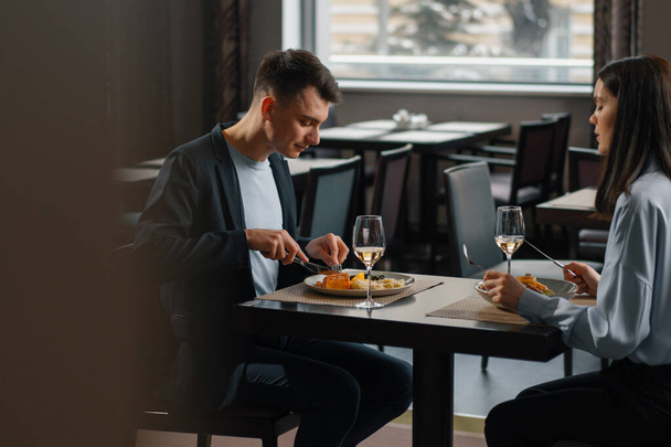 Συνάντηση στο εστιατόριο του ξενοδοχείου του ζευγαριού με κρασί και νόστιμα πιάτα για μεσημεριανό γεύμα - Φωτογραφία, εικόνα