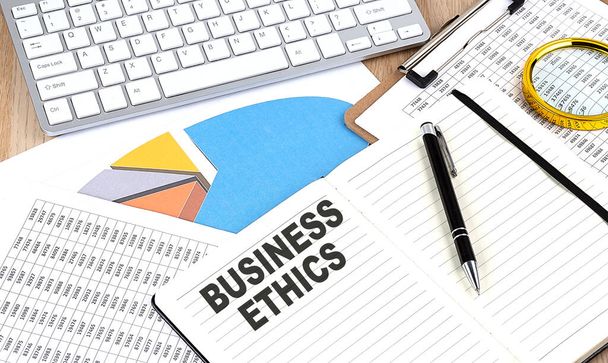 BUSINESS ETHICS tekst op een notebook met grafiek en toetsenbord - Foto, afbeelding