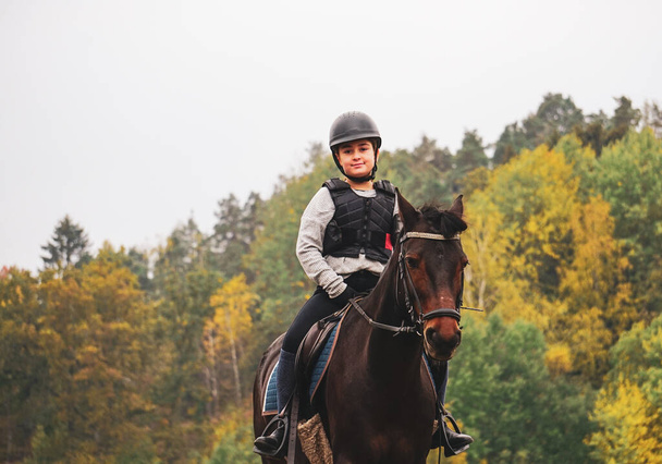 Retrato de un niño sonriente cabalgando a caballo - Foto, imagen