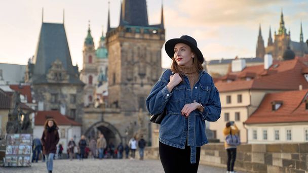 Stylish young beautiful woman earing black hat in Prague on background. Elegant retro lady fine art portrait. - Foto, immagini