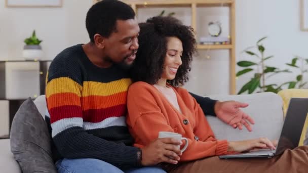 Χαλαρώστε, περιήγηση και διαφυλετικό ζευγάρι με έναν υπολογιστή στον καναπέ για το διαδίκτυο. Μιλώντας, χαρούμενος και μαύρος άνδρας και γυναίκα μιλώντας, ενώ κοιτάζοντας μια ιστοσελίδα σε έναν υπολογιστή, χαμογελώντας και επιλέγοντας μαζί. - Πλάνα, βίντεο