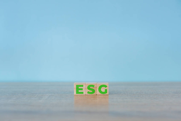 Ξύλινοι κύβοι με συντομογραφία ESG εικονίδια σε μπλε φόντο. ESG έννοια της περιβαλλοντικής, κοινωνικής και διακυβέρνησης. Βιώσιμη ανάπτυξη επιχειρήσεων. Αντιγραφή χώρου. - Φωτογραφία, εικόνα