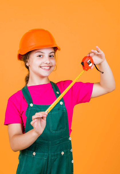 length. construction worker with tape measure. Cute kid as a construction worker. kid repairing home. happy childhood. self-retracting metal tape measure. Little girl using a measuring tape. - Photo, Image