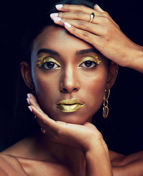 Indian woman, art makeup and studio portrait for beauty, wellness or celebration by black background. Model face, asian girl and dark aesthetic with gold lipstick, jewellery or cosmetic for a queen. - Fotoğraf, Görsel