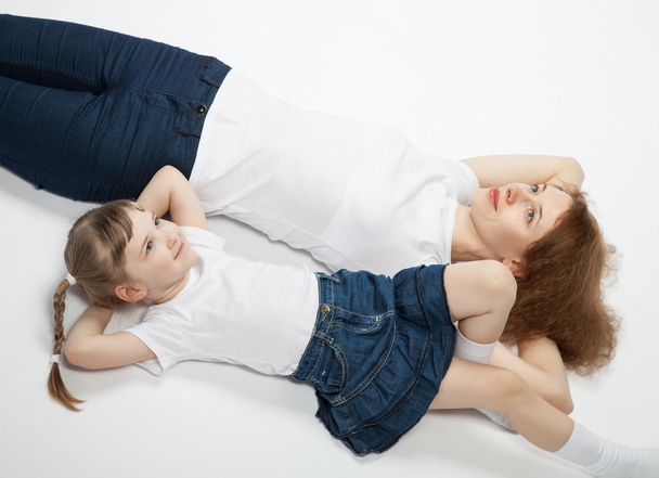 Mother and daughter lying on the floor - 写真・画像