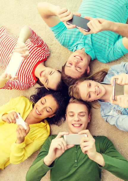 group of smiling people lying down on floor - Foto, immagini