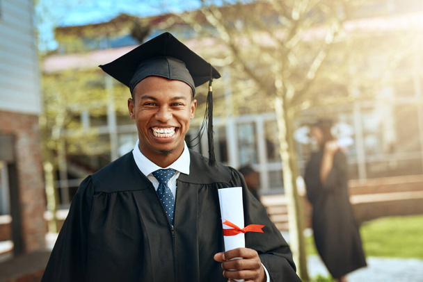 The future sure looks bright from here. Portrait of a happy young man holding a diploma on graduation day - Photo, Image