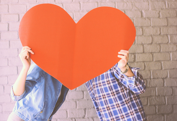 Пара, держащая бумажное сердце
 - Фото, изображение