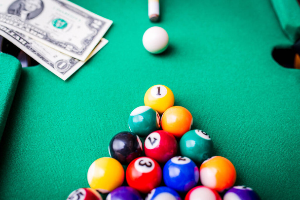 Gambling ardor game.Money and multicolored billiard balls with numbers.Dollar paper banknotes on the game table.Selective focus. - Photo, Image