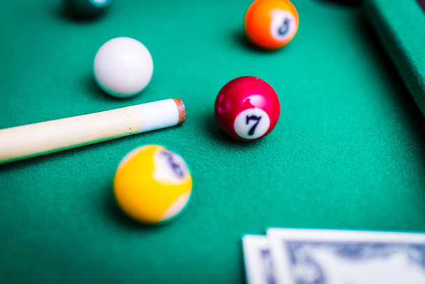Gambling ardor game.Money and multicolored billiard balls with numbers.Dollar paper banknotes on the game table.Selective focus. - Photo, Image