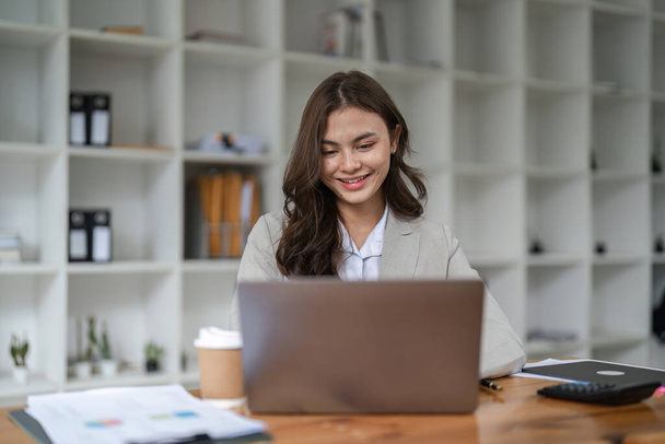Portret Azjatki pracującej z laptopem w biurze. koncepcja finansowa przedsiębiorstwa.. - Zdjęcie, obraz
