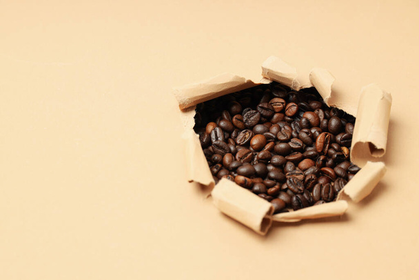 Lyuk a bézs papír kávészemekkel - Fotó, kép