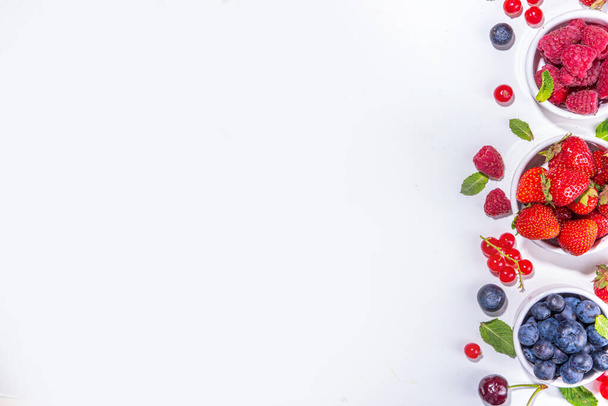 Nyári vitamin élelmiszer koncepció, készlet a különböző bogyók áfonya eper ribizli, lapos feküdt fehér háttér felülnézet másolás hely - Fotó, kép