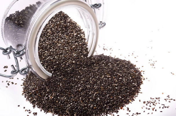 Raw Chia seeds in clear glass airtight jar on white background - Foto, Imagem