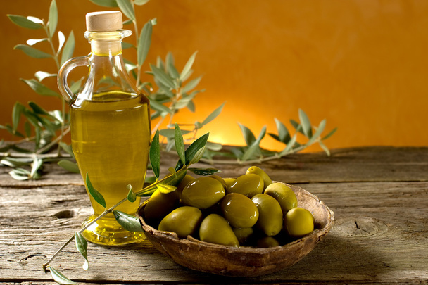 Olive oil on wood background - Foto, imagen