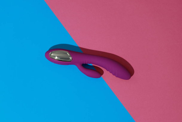 Violet dildo vibrator on colored background with shadows. Sex toy for adult. High quality photo - Fotó, kép