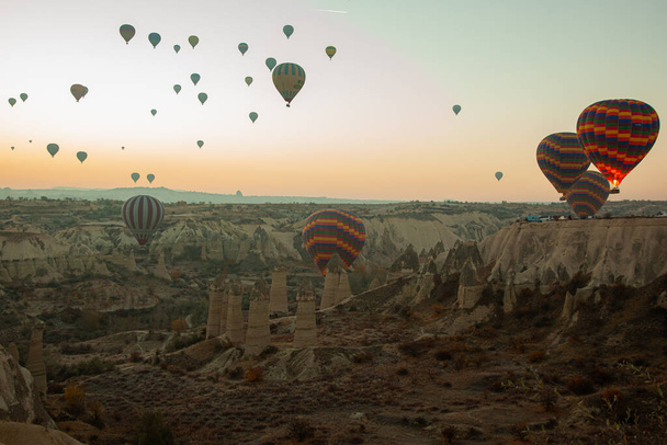 Kapadokya, Türkiye: 22 Kasım 2022: Şafakta Kapadokya 'da gökyüzünde sıcak hava balonları. Türkiye 'nin turistik yeri. Kapadokya 'da Aşk Vadisi. - Fotoğraf, Görsel