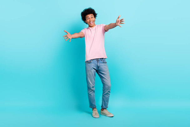 Full body size photo of friendly young man wear trendy outfit t-shirt denim levis jeans advert embrace you isolated on aquamarine color background. - Photo, image