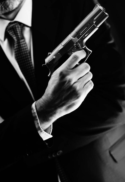 Bem vestido agente secreto masculino detetive espião vestindo terno e gravata segurando pistola automática. - Foto, Imagem