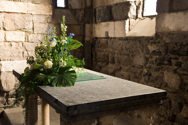 Kamenný oltář s květinami ve starověkém italském románském kostele  - Fotografie, Obrázek