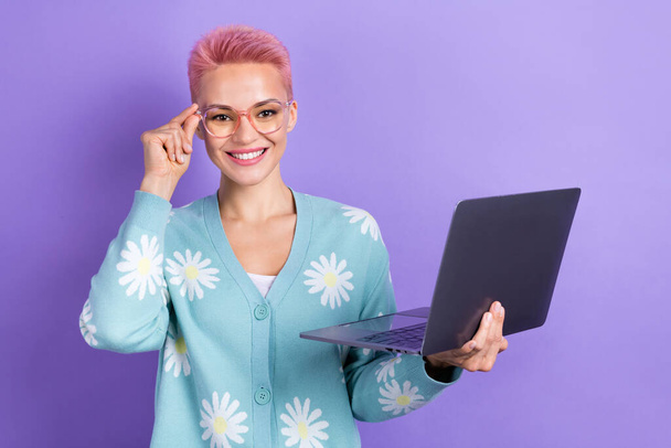 Photo of optimistic adorable woman short hairstyle dressed blue cardigan hold laptop touch glasses isolated on purple color background. - Photo, image