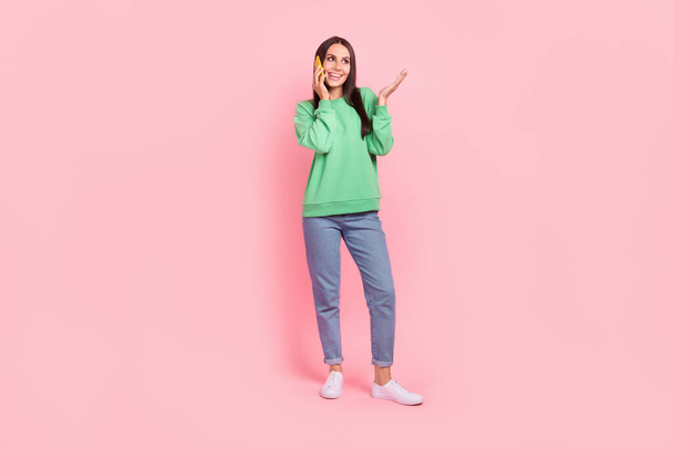 Full length photo of positive adorable lady freelancer wear stylish clothes speaking friends empty space isolated on pink color background. - Zdjęcie, obraz