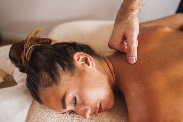 close-up shot van een vrouw het krijgen van een relax terug massage in de schoonheidssalon. - Foto, afbeelding
