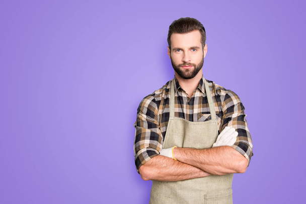Portrait with copyspace, empty place of attractive, virile, harsh farmer with stubble in uniform having his arms crossed, looking at camera isolated on grey background, advertisement concept. - Foto, afbeelding