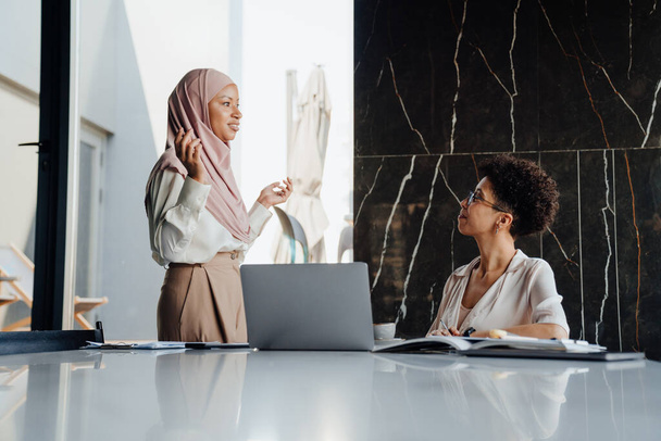 Middle-aged businesswoman and her female assistant talking together while working in office - Valokuva, kuva