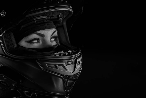 Portret pewnej siebie motocyklistki w zamkniętym kasku. Młody motocyklista w czerni i bieli - Zdjęcie, obraz