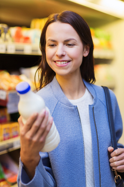 happy woman holding milk bottle in market - Фото, зображення