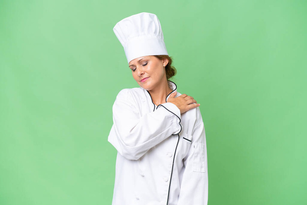 Женщина-повар средних лет на изолированном фоне, страдающая от боли в плече за то, что сделала усилие - Фото, изображение