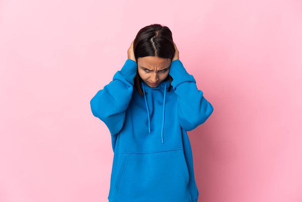 Молодая латинская женщина изолированы на розовом фоне разочарование и покрытие ушей - Фото, изображение