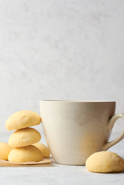 ghee biscuits or cookies on table with a tea cup, against blurry white textured background, homemade melt in mouth nei biscuits, eggless cookies are made whole wheat flour, selective focus, copy space - 写真・画像