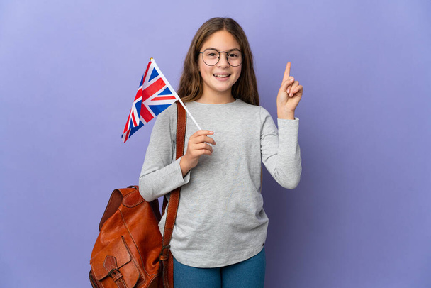 Child holding an United Kingdom flag over isolated background pointing up a great idea - Fotó, kép