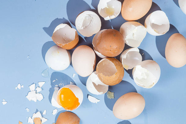 Raw eggs on a blue background. Eggshell - Foto, afbeelding