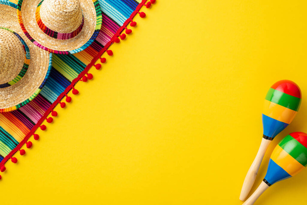 Meksika ulusal bayramı konsepti. Marakas şapkalarının ve izole edilmiş sarı arkaplanlı renkli çizgili serapın üst görünüm fotoğrafı. - Fotoğraf, Görsel