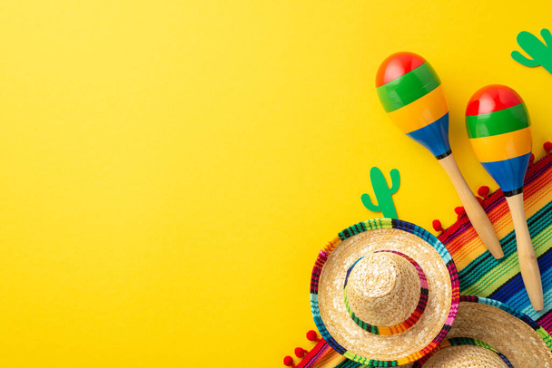 Concetto Cinco-de-mayo. Foto vista dall'alto di cappelli sombrero colorati strisce serape cactus silhouette e coppia di maracas su sfondo giallo vibrante isolato con spazio vuoto - Foto, immagini