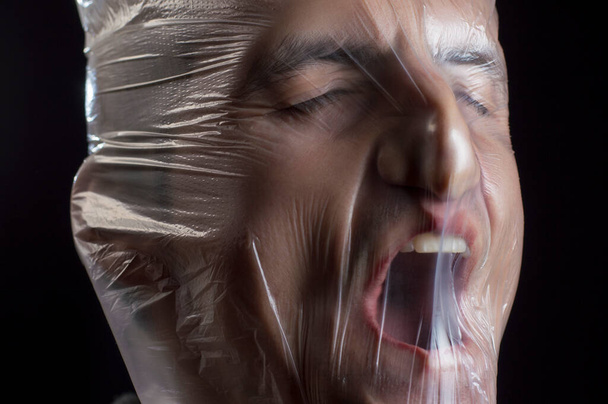 Nahaufnahme Porträt einer Plastiktüte auf dem Gesicht Erstickung - Foto, Bild